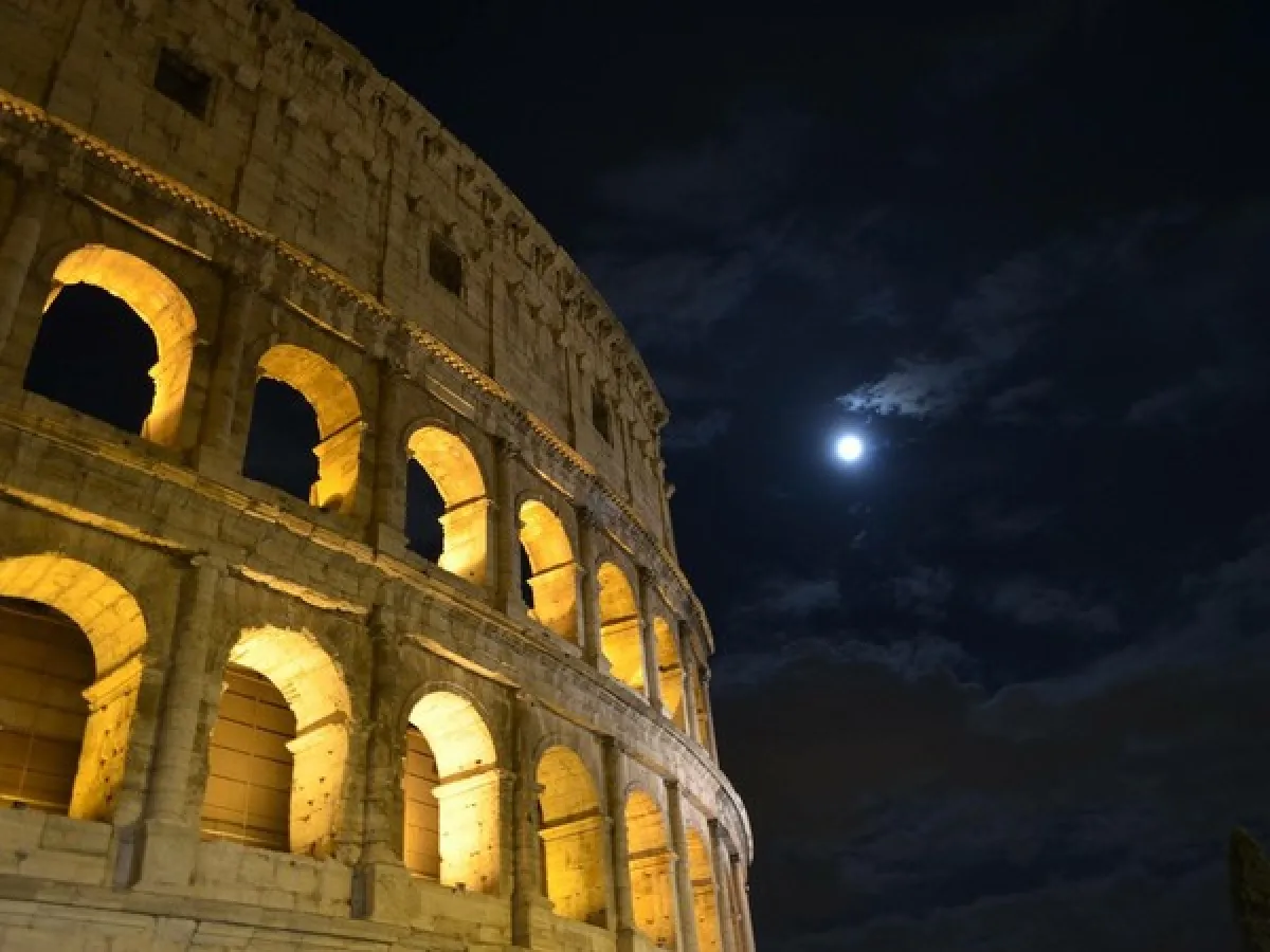 Flacone del profumo Roma Uomo di Laura Biagiotti su uno sfondo chiaro con un drappo di tessuto beige in primo piano, che esalta il design elegante della bottiglia nera.